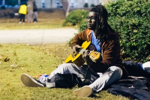 Freshman communication major Broderick Armbrister strums his guitar outside the Social Sciences Building, where students set up tents for the sleep out. Credit: Photo: Matt Boggs | The Sentinel