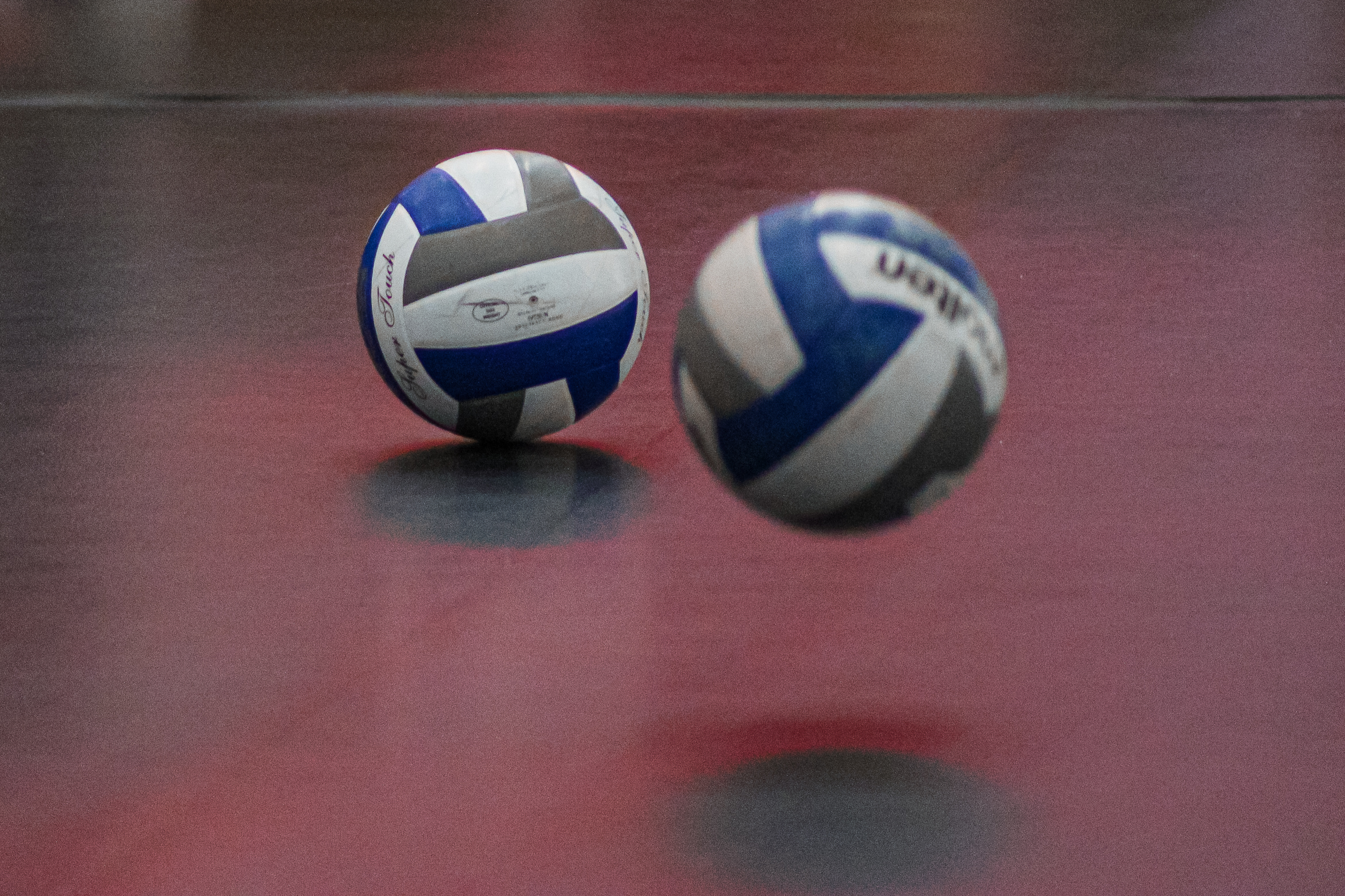 Volleyballs bouncing on the court.