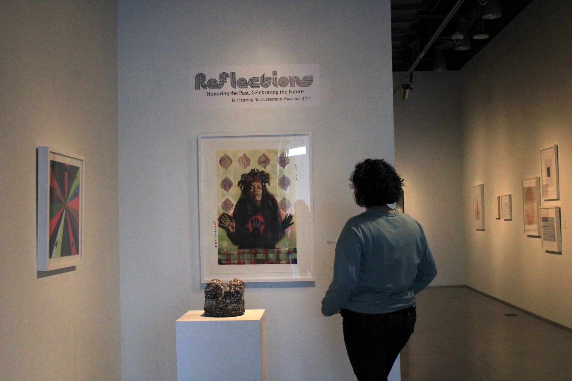 KSU student Caitlyn David admiring the work in the Reflections exhibit.