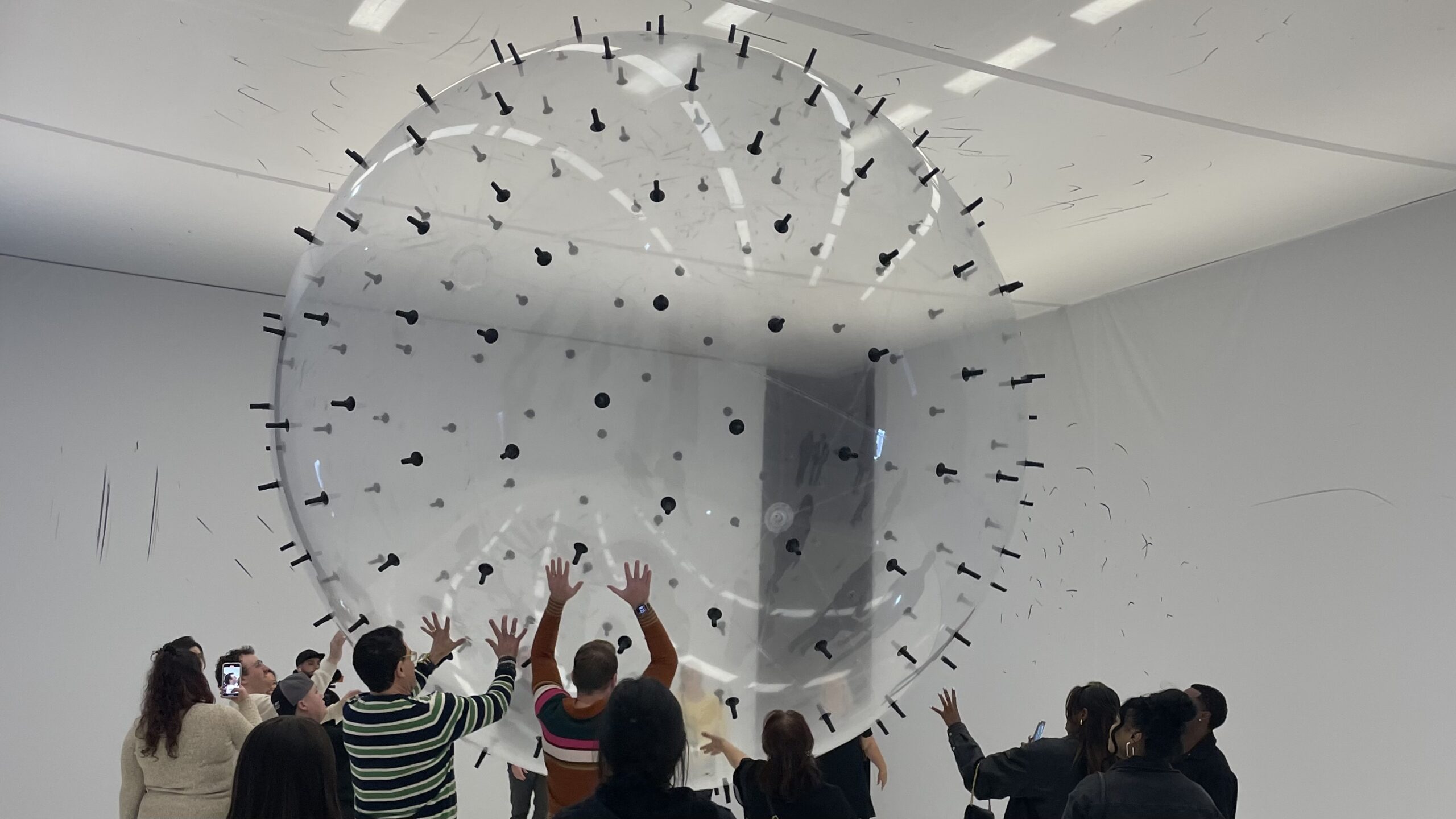 Visitors interacted with an exhibit at the Balloon Museum. This bouncy ball was pushed around in a white room to make black marks on the walls.