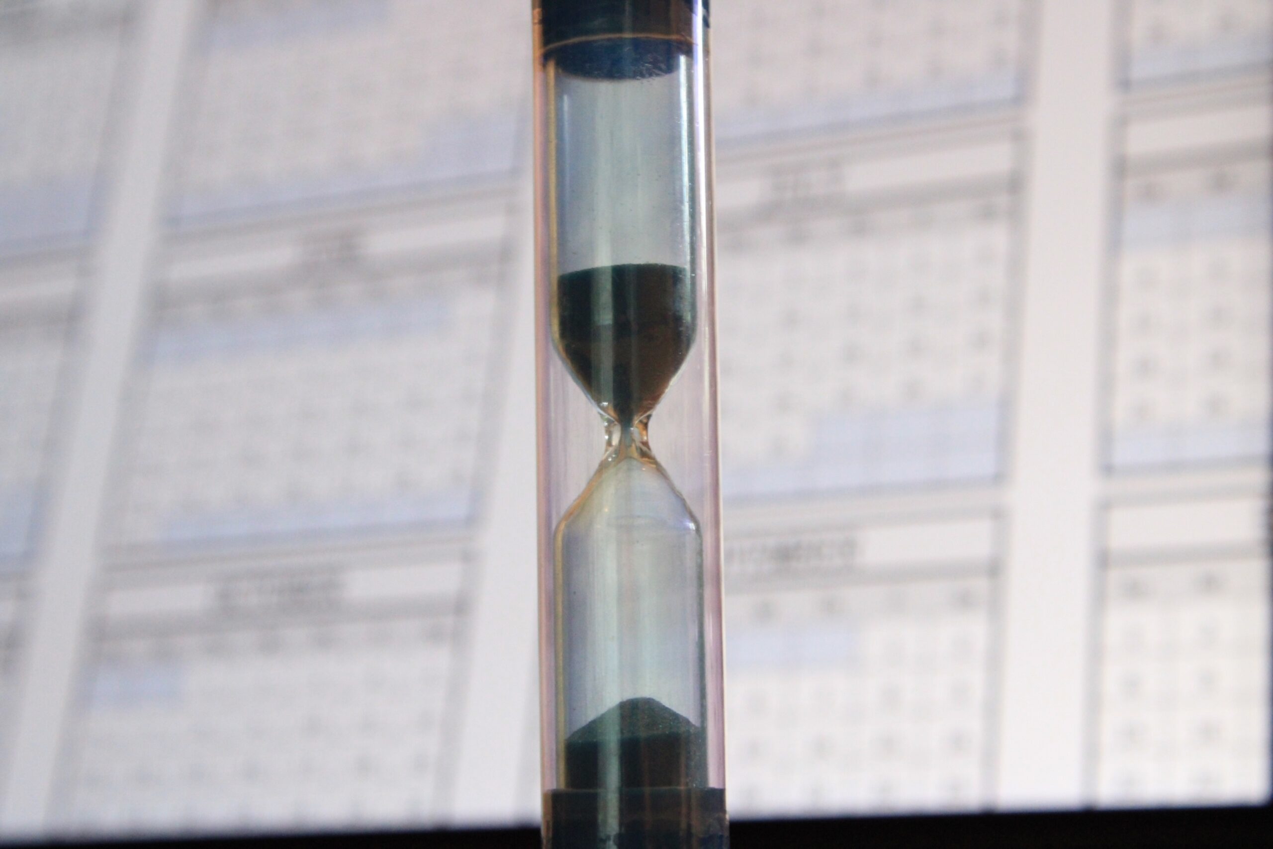 An hourglass with calendars in the background